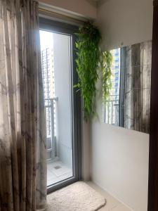 een kamer met een raam met een plant bij Cozy 1 bedroom with Balcony in Manilla