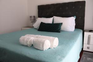 a bed with two rolled up towels on it at Alexia Room in Funchal