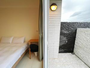 1 dormitorio con 1 cama junto a una ventana en 日子有光 SHINE Inn Day, en Hengchun