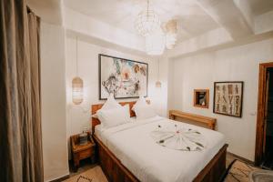 a bedroom with a large bed with white sheets at La Ferme Medina in Marrakech
