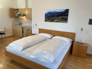 ein großes Bett in einem Zimmer mit Küche in der Unterkunft Residence Nesslerheim in Tramin an der Weinstraße