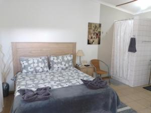 a bedroom with a bed and a chair in it at Aub Guesthouse - Mariental in Mariental