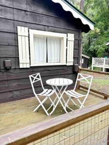 dos sillas y una mesa en la cubierta de una cabina en The Garden Cottage, en Hendersonville