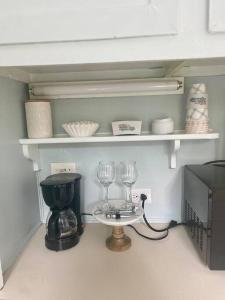 a shelf with two wine glasses and a coffee maker at The Garden Cottage in Hendersonville