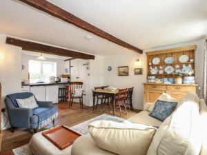 a living room with a couch and a table at Horseshoe Cottage in Pentney