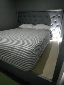 uma cama com duas almofadas num quarto em Hostel la Antigua Capsula em Cartagena de Indias