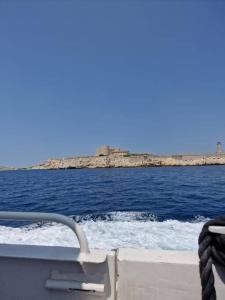 a boat in the water with a view of the ocean at Une parenthèse au Frioul in Marseille +1 photo