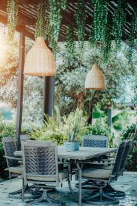 einen Tisch und Stühle auf einer Terrasse mit Pflanzen in der Unterkunft RH Boutique Hotel Aruba in Oranjestad