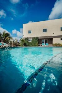 a swimming pool in front of a building at RH Boutique Hotel Aruba in Oranjestad