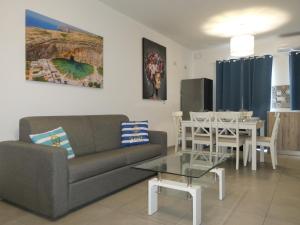 uma sala de estar com um sofá e uma mesa em Blue Sky Apartments em Mġarr