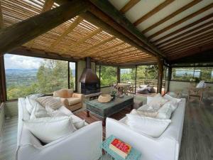 a living room with white couches and a fireplace at LAS NUBES - Donde la energía fluye, el alma se cura in Rionegro +37 photos