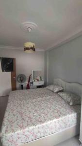 a bedroom with a large bed with a floral bedspread at Tınaztepe kampüse 5 dk 1+1 daire in Buca