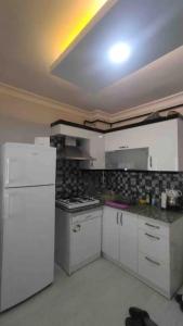 a kitchen with white cabinets and a white refrigerator at Tınaztepe kampüse 5 dk 1+1 daire in Buca +2 photos