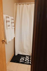 ein Bad mit einer Dusche mit einem weißen Duschvorhang in der Unterkunft Laid-back - Industrial Chic - Game room in Lincoln + 23 Fotos