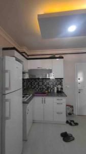 a kitchen with white cabinets and a white refrigerator at Tınaztepe kampüse 5 dk 1+1 daire in Buca
