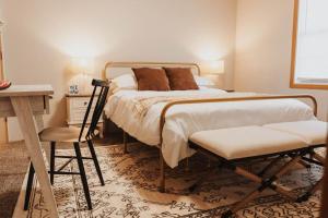 ein Schlafzimmer mit einem Bett, einem Schreibtisch und einem Stuhl in der Unterkunft Laid-back - Industrial Chic - Game room in Lincoln