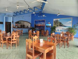 a dining room with wooden tables and chairs at Hotel y Restaurante El Marino in Santa Cruz