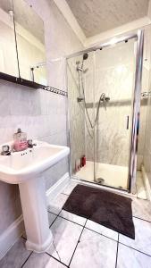 a white bathroom with a shower and a sink at Aldgate Rooms in London