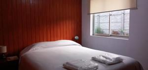 1 dormitorio con 1 cama con 2 toallas en El Rincon de los Poetas, en Nueva Imperial