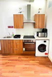a kitchen with a sink and a stove top oven at Aldgate Rooms in London