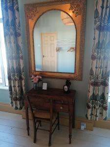 a dressing table with a mirror and a chair at No. 30 in Aberdare