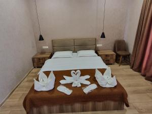 a bedroom with a bed with two flowers on it at Hotel Sweet Night in Kazbegi