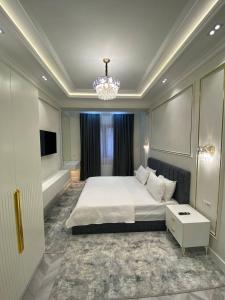 a bedroom with a large bed and a chandelier at Happy home in Tashkent