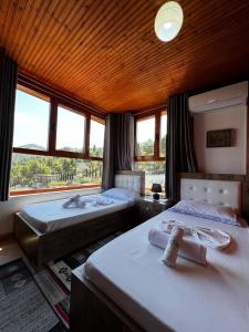 a bedroom with two beds and a large window at Guesthouse Emiljano in Berat