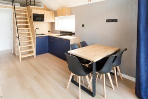 a kitchen and dining room with a wooden table and chairs at Holiday Golden Resort & Spa in Łazy