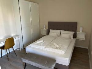 1 dormitorio con 1 cama con 2 toallas en H30 Apartman, en Pécs