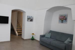 ein Wohnzimmer mit einem Sofa und einer Treppe in der Unterkunft Casetta Pisanelli 25 in Mottola