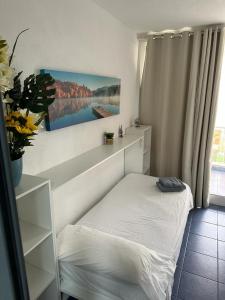 a small bedroom with a bed and a window at La envia golf in Vícar