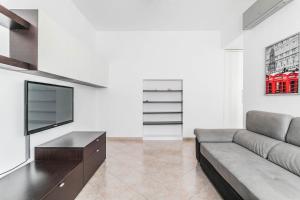 salon z kanapą i telewizorem z płaskim ekranem w obiekcie Appartamento Trilocale 95mq Milano - Bocconi e Navigli w Mediolanie