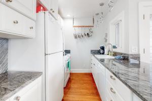 a kitchen with white cabinets and marble counter tops at Berni's Crow's Nest in Oceanside