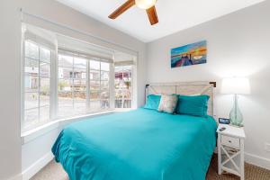a bedroom with a blue bed and a window at Berni's Crow's Nest in Oceanside