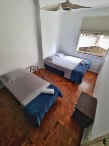 Duas camas num quarto com uma janela em Apartamento Alameda Santos - By Capsula Hotel em São Paulo