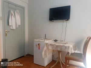 um quarto com uma mesa, uma televisão e um frigorífico em Aconchego do Lar Centro BH Apto 633 Rua da Bahia 187 em Belo Horizonte