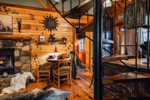 a dining room with a table and a stone fireplace at Lazy Fox Hideout in Sevierville