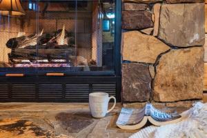 a coffee cup and boots next to a fireplace at Lazy Fox Hideout in Sevierville
