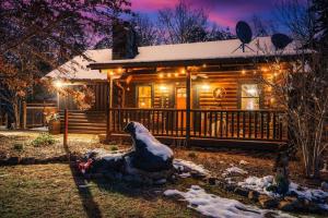 a log cabin with a christmas decoration in front of it at Lazy Fox Hideout in Sevierville
