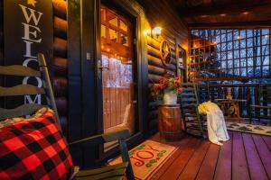 a porch of a cabin with a door and flowers at Lazy Fox Hideout in Sevierville