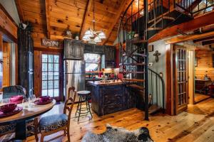 a kitchen with a wooden ceiling and a table with chairs at Lazy Fox Hideout in Sevierville