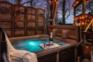 a hot tub with a table and a bottle of wine at Lazy Fox Hideout in Sevierville