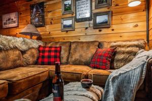 a living room with a couch and a bottle of wine at Lazy Fox Hideout in Sevierville