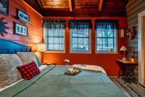 a bedroom with a bed with red walls and windows at Lazy Fox Hideout in Sevierville