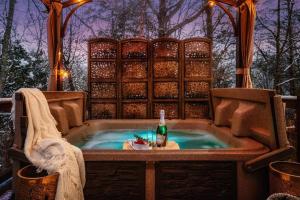 a jacuzzi tub with a bottle of wine in it at Lazy Fox Hideout in Sevierville