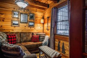a living room with a couch in a log cabin at Lazy Fox Hideout in Sevierville