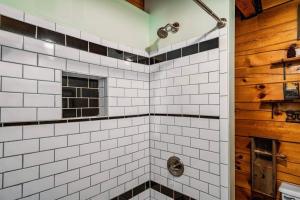 a bathroom with a shower with white tiled walls at Lazy Fox Hideout in Sevierville