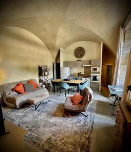 ein großes Wohnzimmer mit einem Sofa und einem Tisch in der Unterkunft Au pays de Gide appart feutré dans un château in Lussan