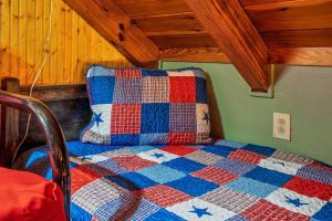 a bed with a quilt on it in a room at Lazy Fox Hideout in Sevierville
